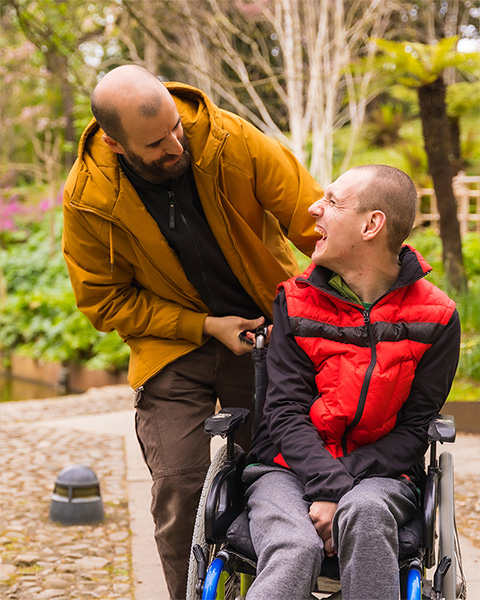 Carer with man in wheelchair outside