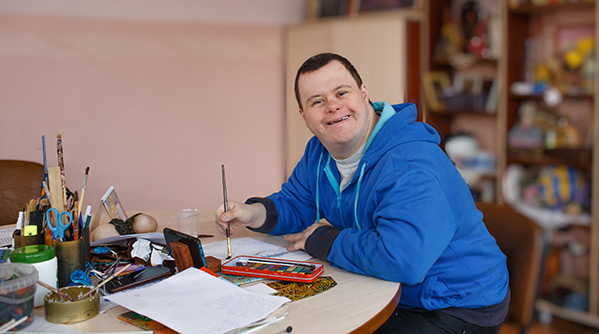 Man with down syndrome painting