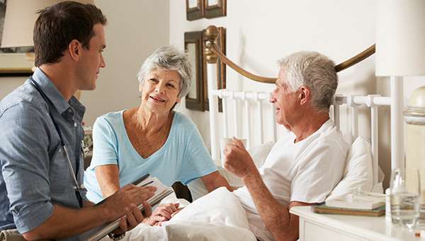 Senior man in bed being checked by doctor