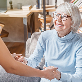 Senior woman holding hands with carer