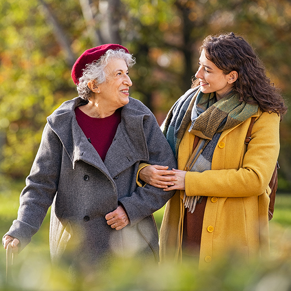 Outside walking carer and senior woman