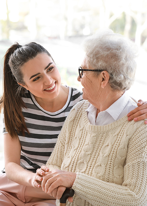 Smiling carer with elderly woman